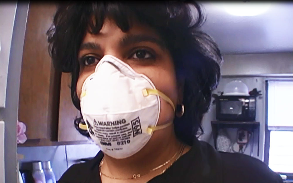 Elizabeth wears a mask to clean mold